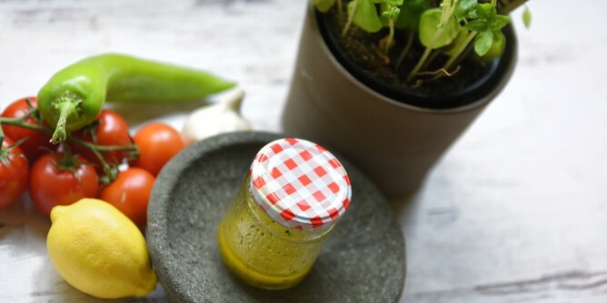 Dressing | © SONNENTOR Auf dem Foto sieht man ein Glas mit Dressing. Daneben liegen Paprika, Tomaten und eine Zitrone. | © SONNENTOR