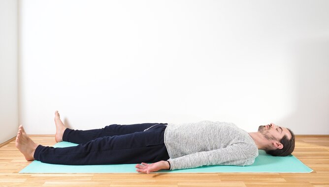 Savasana Darmgesundeit | © SONNENTOR Foto eines Mannes der Yoga für einen gesunden Darm ausführt. | © SONNENTOR