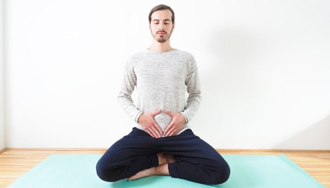 Yoga Darmgesundheit | © SONNENTOR Auf dem Foto ist ein Mann bei der Bauchatmung zu sehen. | © SONNENTOR